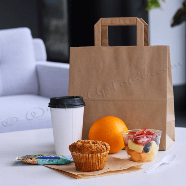 Breakfast to-go: coffee, orange, muffin, and fruit.
