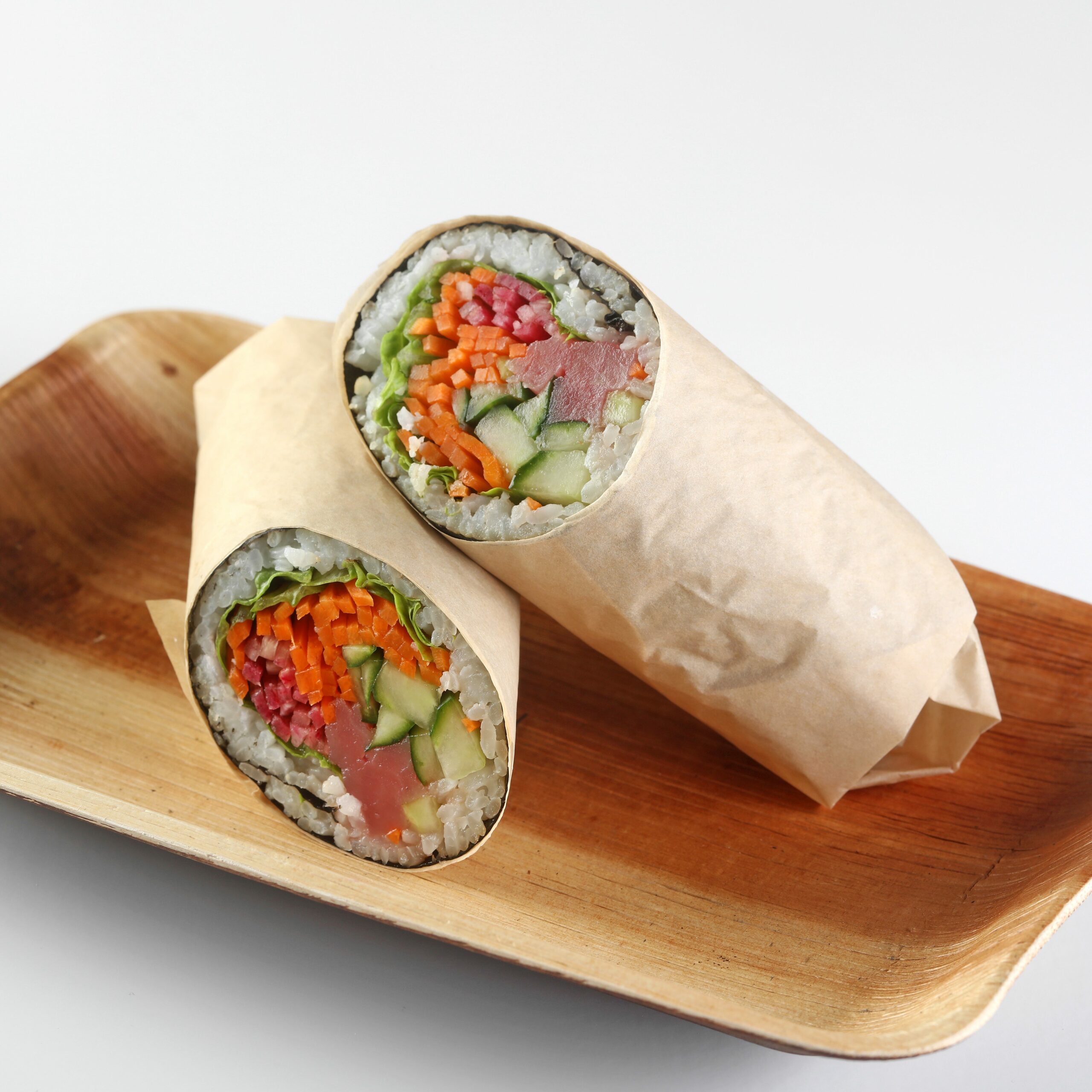 Sushi burrito with vegetables on wooden plate
